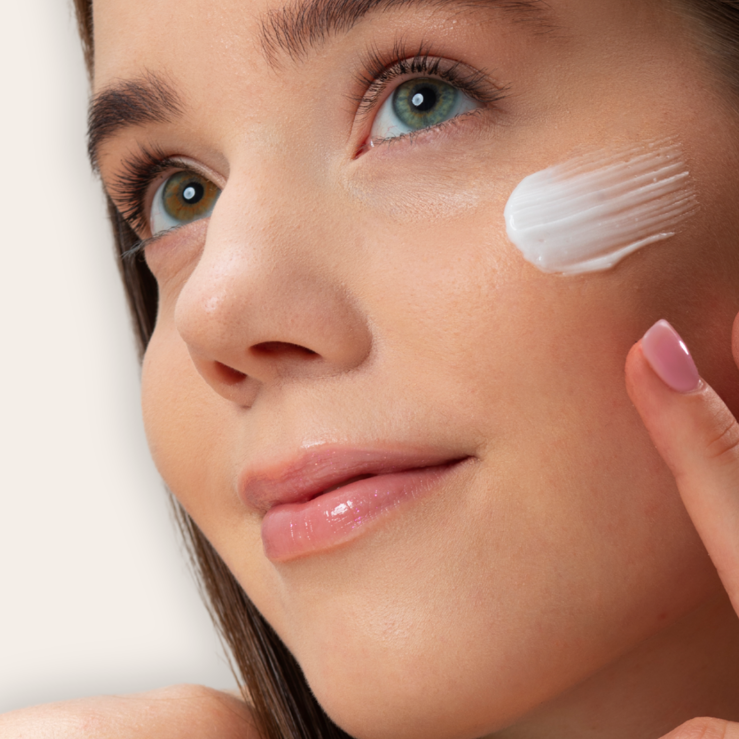 adolescente étalant de la créme hydratante sur le visage