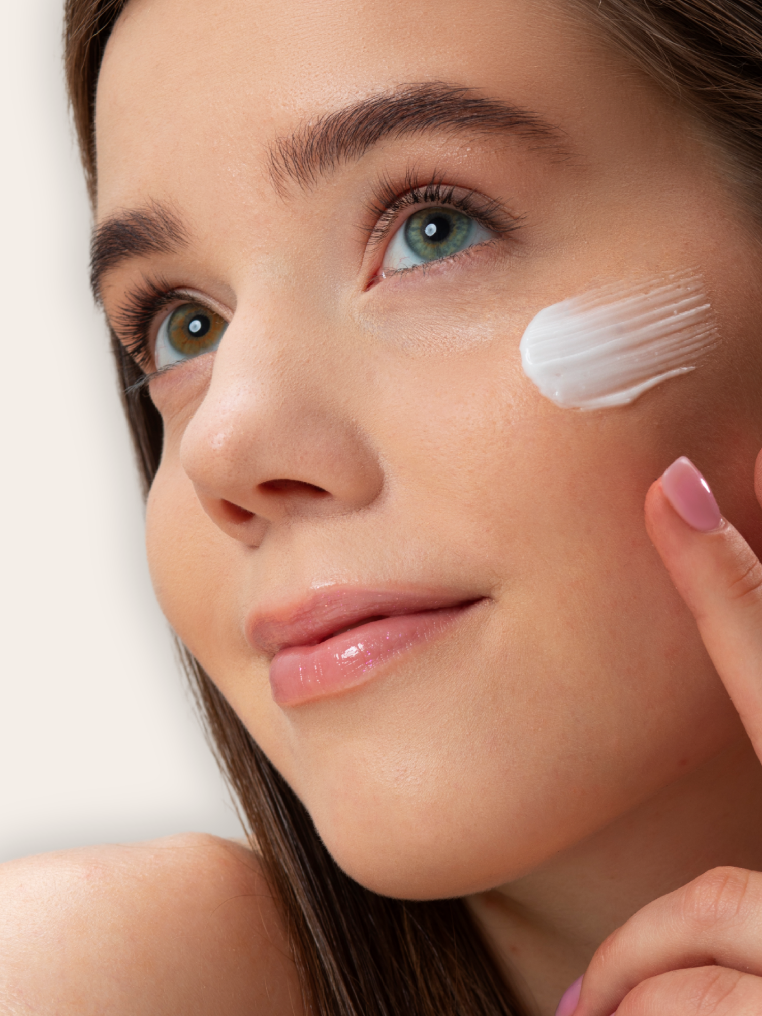 adolescente étalant de la créme hydratante sur le visage
